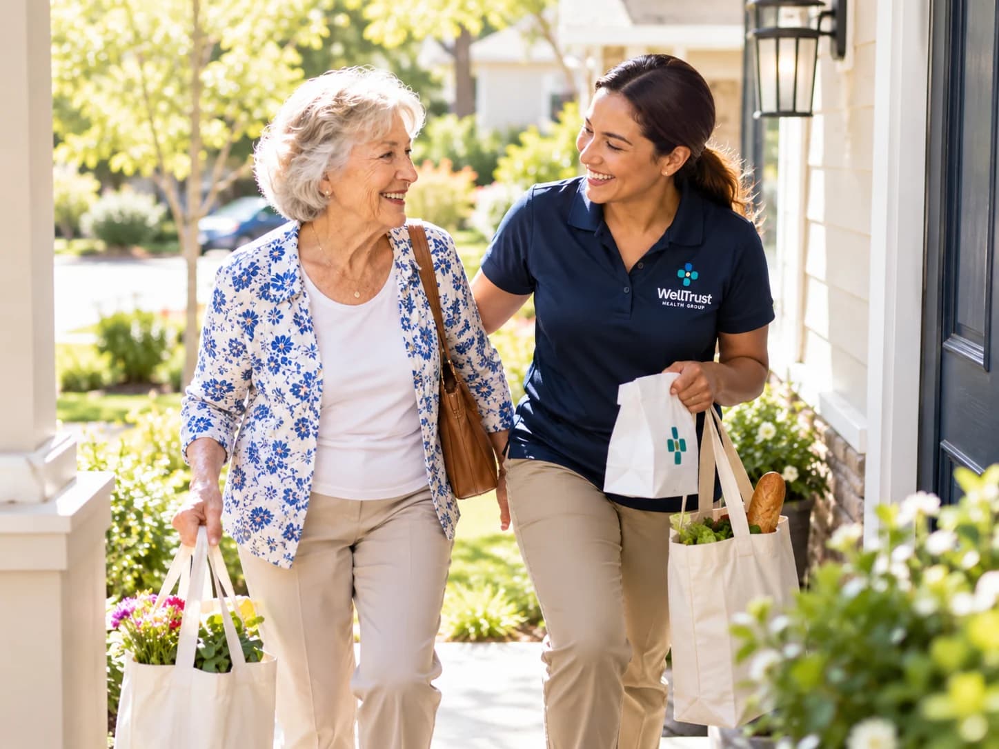 An older woman and a WellTrust companion carrying groceries and a pharmacy bag to her front door